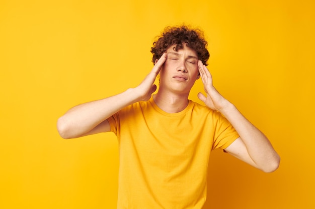 Portrait d'un jeune homme bouclé tshirt jaune mode gestes de la main fond isolé inchangé