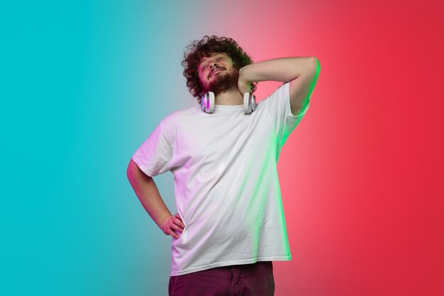 Portrait de jeune homme caucasien sur fond de studio dégradé en néon