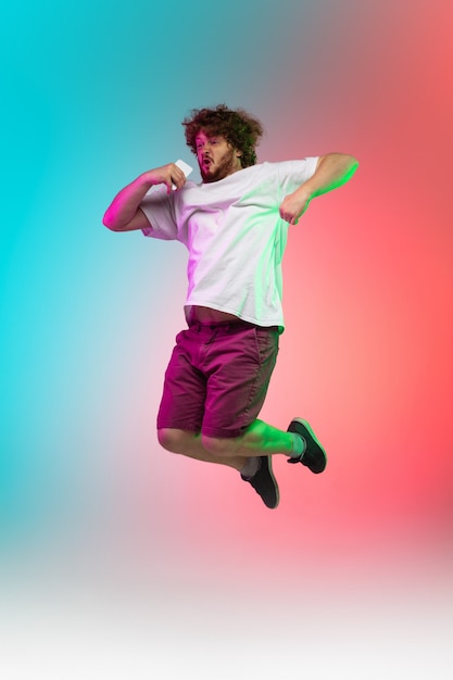 Portrait de jeune homme caucasien sur fond de studio dégradé en néon