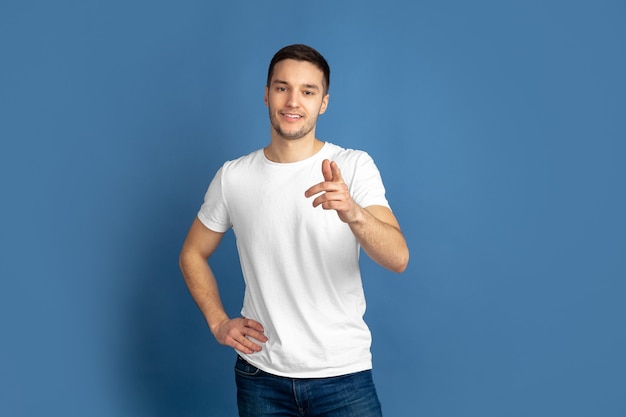 Portrait de jeune homme caucasien sur mur bleu