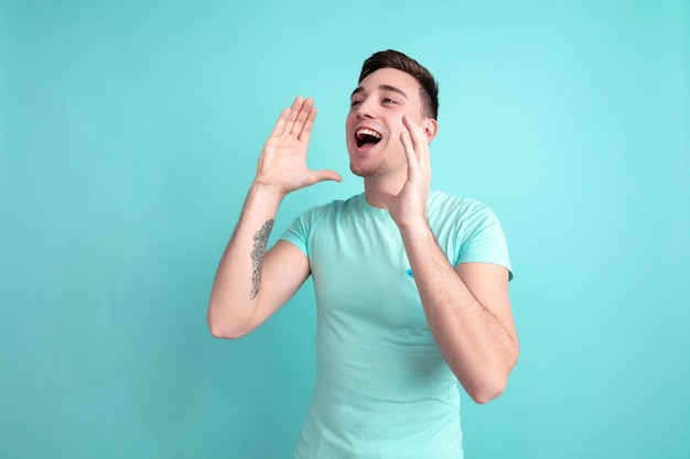 Portrait de jeune homme caucasien sur mur bleu