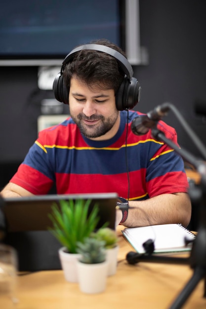 Portrait de jeune homme caucasien présentateur de radio ou podcasteur travaillant en studio d'enregistrement