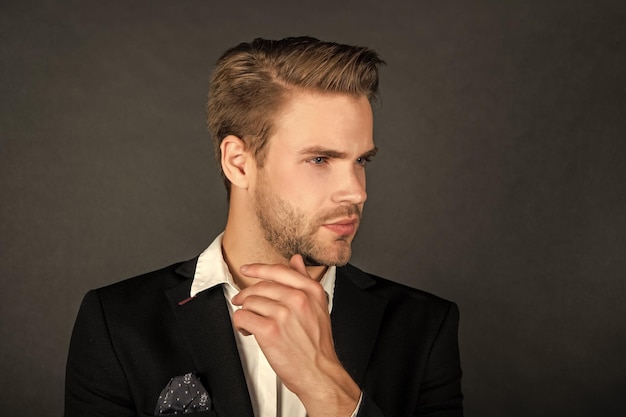 portrait d'un jeune homme en chemise blanche sur fond noir à la mode