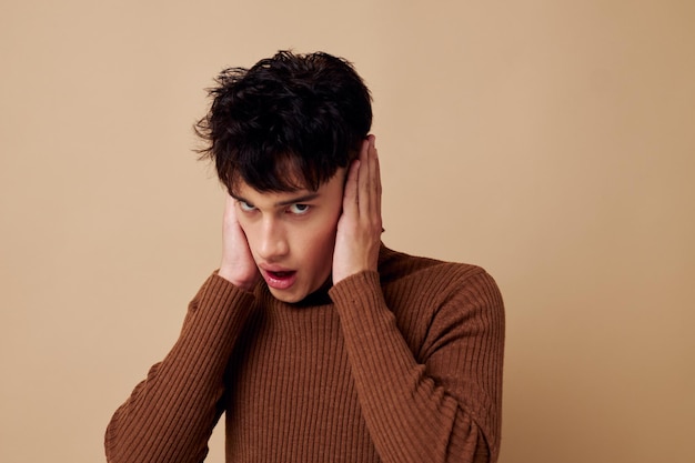 Portrait d'un jeune homme coiffure élégante col roulé brun fond clair inchangé