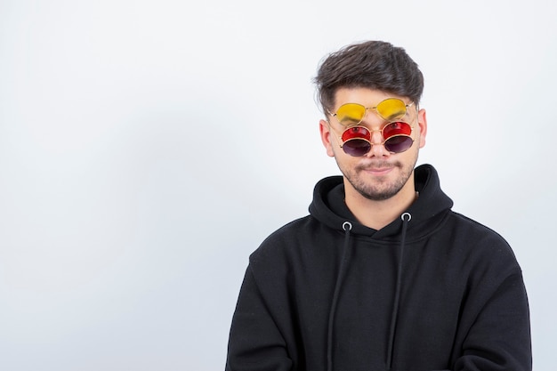 Portrait de jeune homme confiant avec coiffure dans des verres élégants