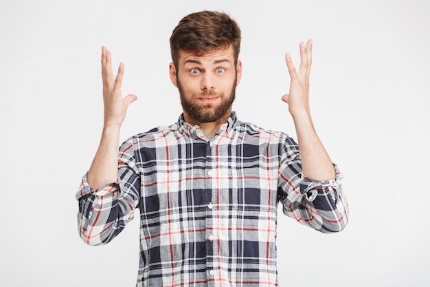 Portrait d'un jeune homme confus en chemise à carreaux