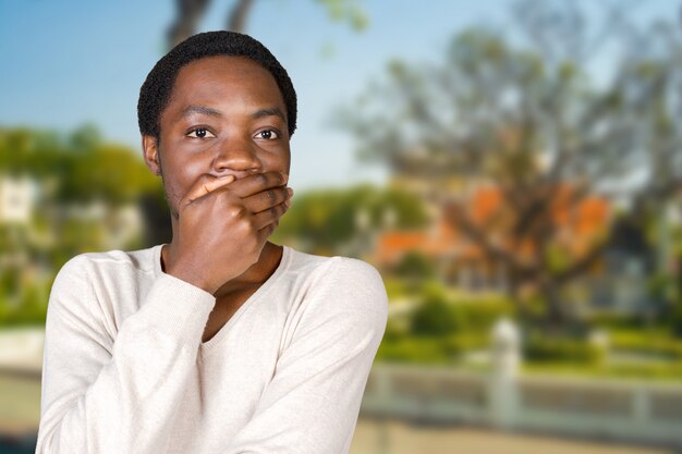 Portrait de jeune homme couvrant sa bouche