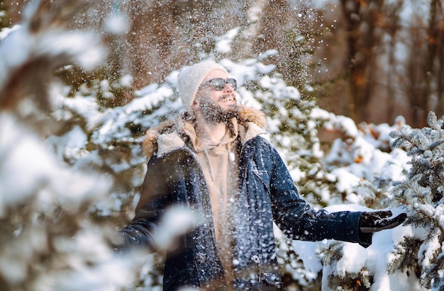 Portrait de jeune homme dans la forêt d'hiver enneigée Concept de voyages et de personnes de Noël