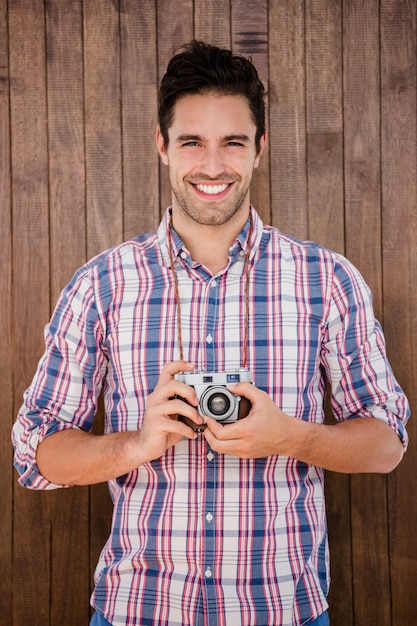 Portrait de jeune homme debout avec un appareil photo numérique