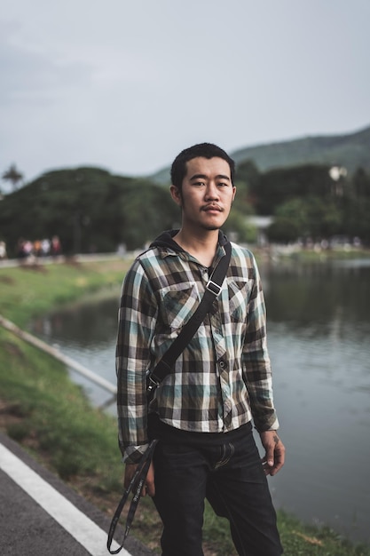 Portrait d'un jeune homme debout contre le lac