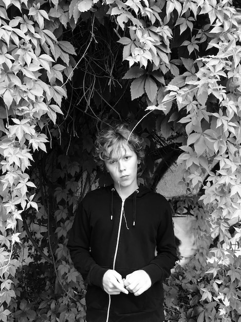 Portrait d'un jeune homme debout contre des plantes