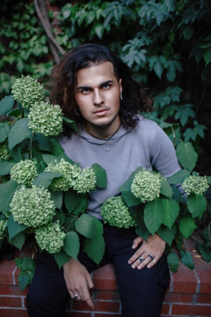 Photo portrait d'un jeune homme debout contre des plantes