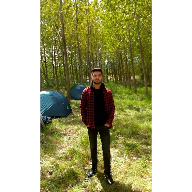 Photo portrait d'un jeune homme debout dans la forêt