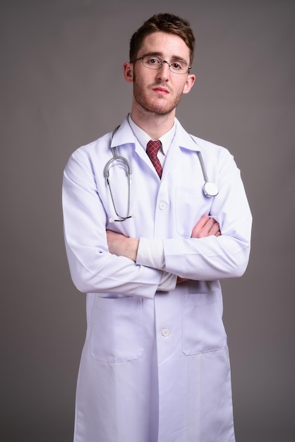 Portrait d'un jeune homme debout sur un fond gris