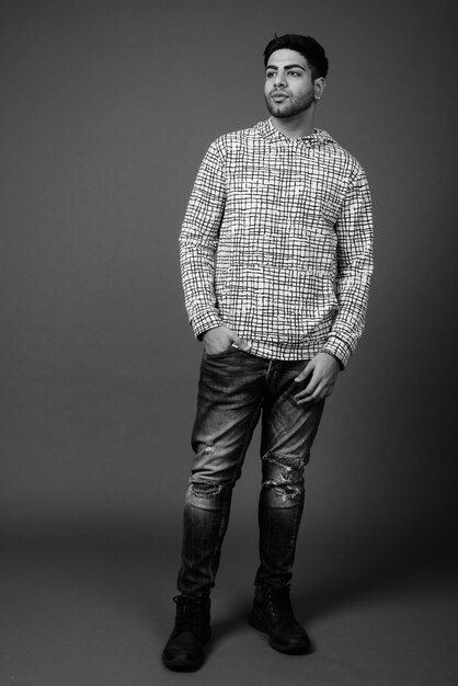 Photo portrait d'un jeune homme debout sur un fond gris