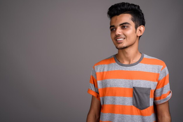 Photo portrait d'un jeune homme debout sur un fond gris