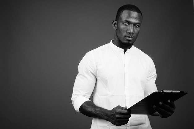 Photo portrait d'un jeune homme debout sur un fond gris