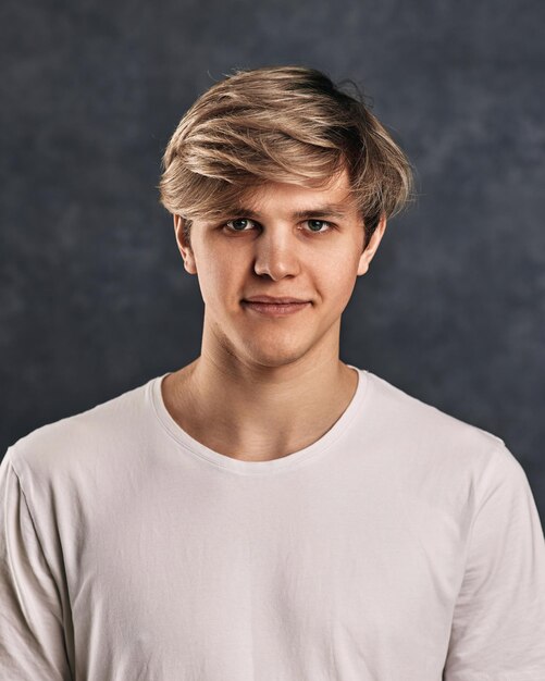 Photo portrait d'un jeune homme debout sur un fond noir