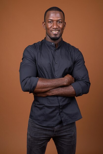 Portrait d'un jeune homme debout sur un fond orange