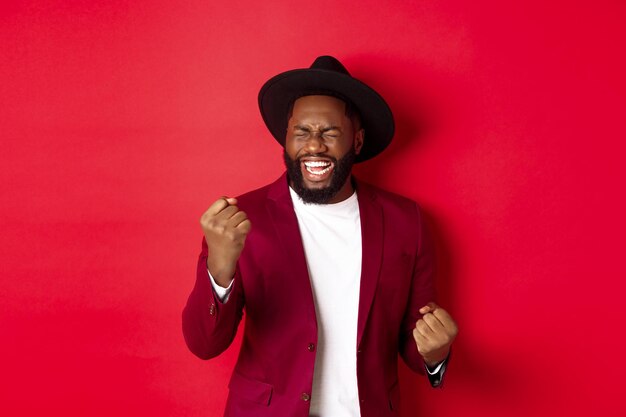 Photo portrait d'un jeune homme debout sur un fond rouge