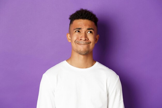 Photo portrait d'un jeune homme debout sur un fond violet