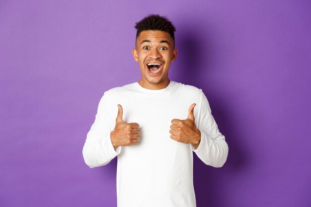 Portrait d'un jeune homme debout sur un fond violet