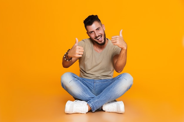 Portrait d'un jeune homme décontracté heureux assis