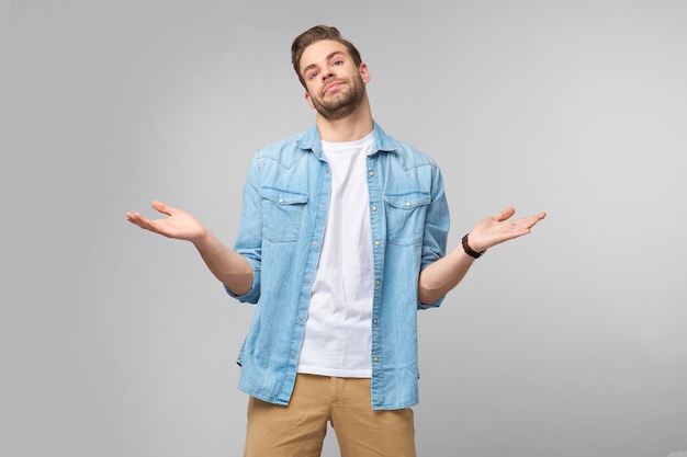 Portrait de jeune homme désemparé confus en chemise de jeans debout