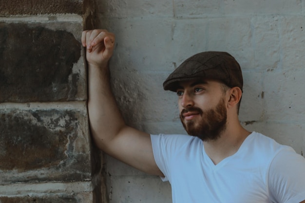 Photo portrait d'un jeune homme détournant le regard contre le mur