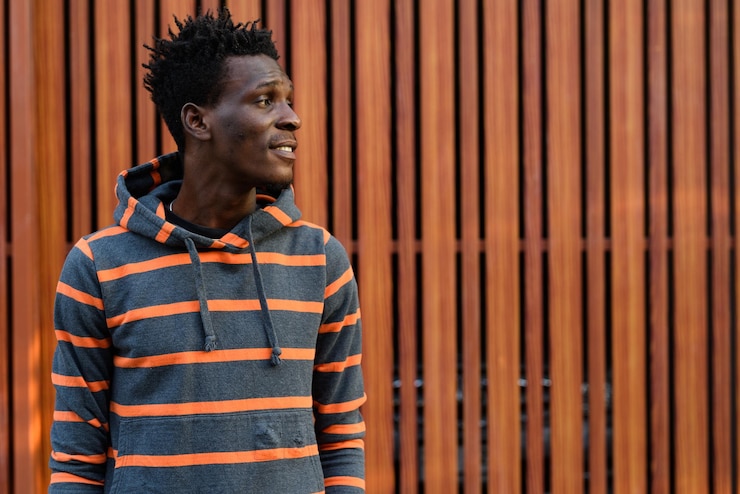 Photo portrait d'un jeune homme détournant le regard contre le mur