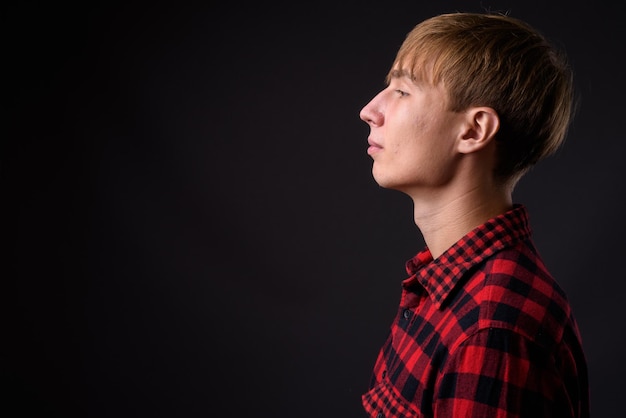 Photo portrait d'un jeune homme détournant le regard sur un fond noir