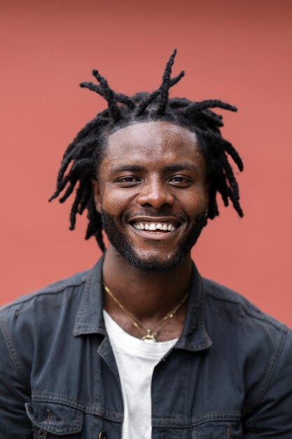 Portrait de jeune homme avec des dreadlocks afro et une veste