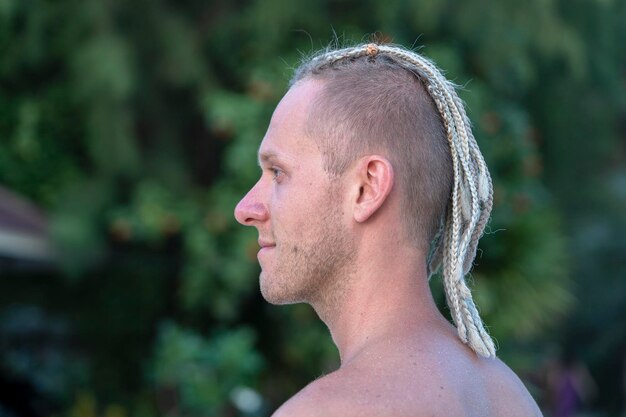 Portrait d'un jeune homme avec des dreadlocks sur la tête dans la nature Gros plan