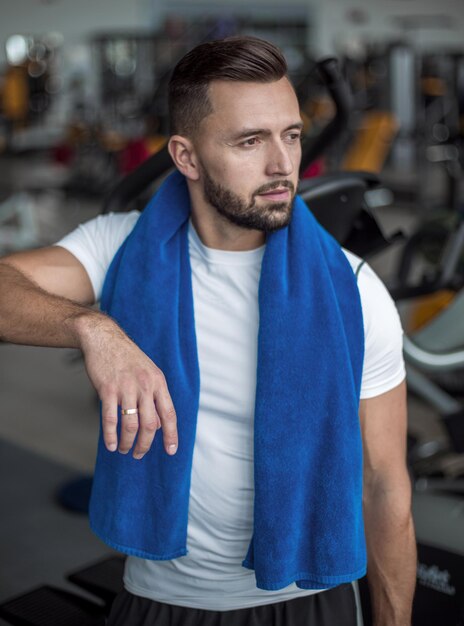 Portrait d'un jeune homme élégant debout dans une salle de sport