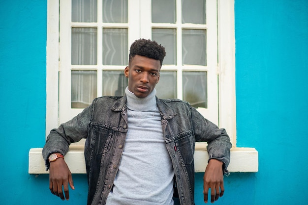 Portrait de jeune homme élégant sur fond bleu