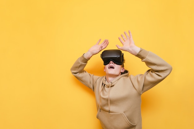 Portrait de jeune homme émotionnel à lunettes VR isolé