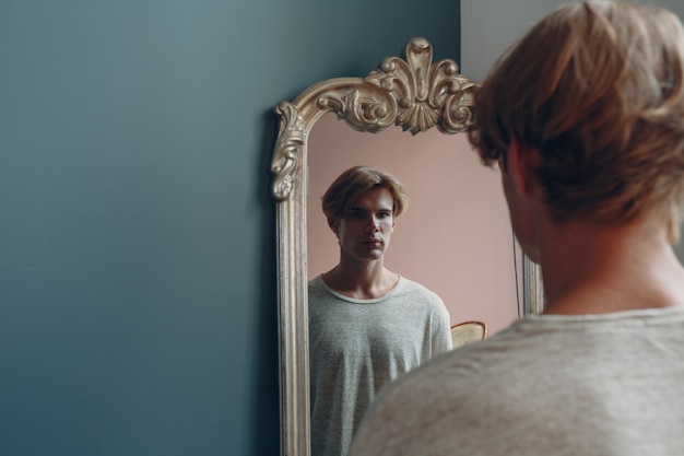 Photo portrait jeune homme européen avec portrait miroir au studio indoor