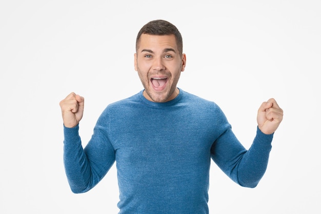 Portrait de jeune homme excité célébrant le succès isolé sur fond blanc