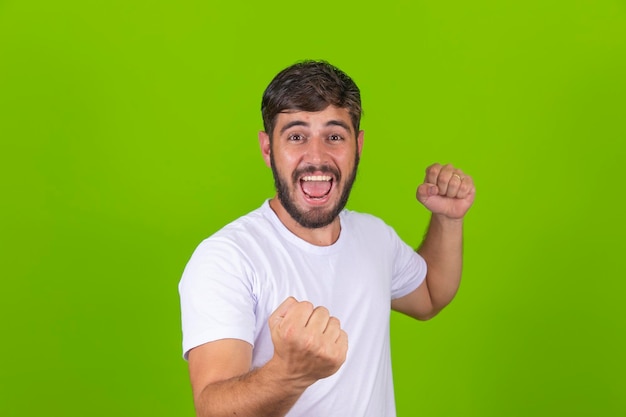 Portrait de jeune homme excité célébrant la victoire