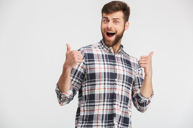 Portrait d'un jeune homme excité en chemise à carreaux