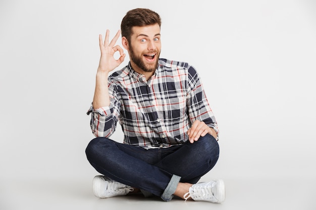 Portrait d'un jeune homme excité en chemise à carreaux