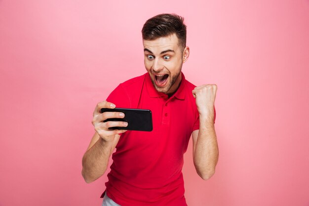 Portrait d'un jeune homme excité à jouer à des jeux