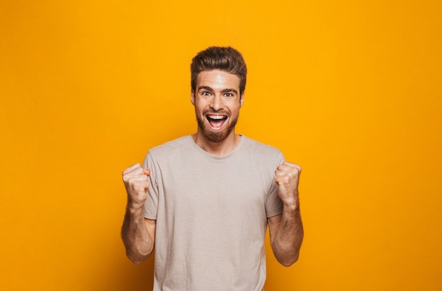 Photo portrait d'un jeune homme heureux célébrant le succès