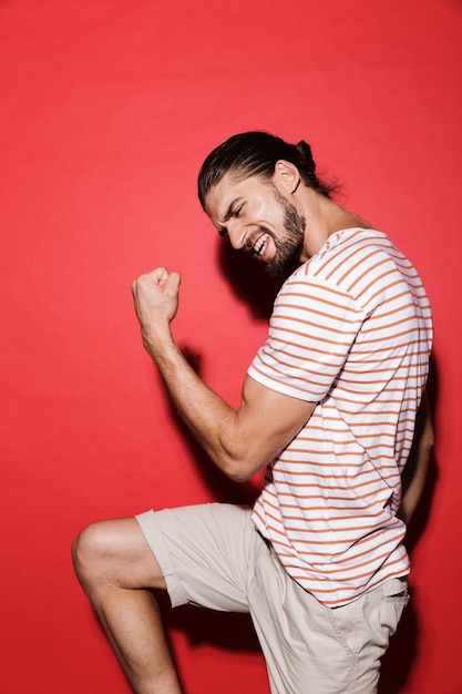 Portrait d'un jeune homme heureux isolé sur rouge