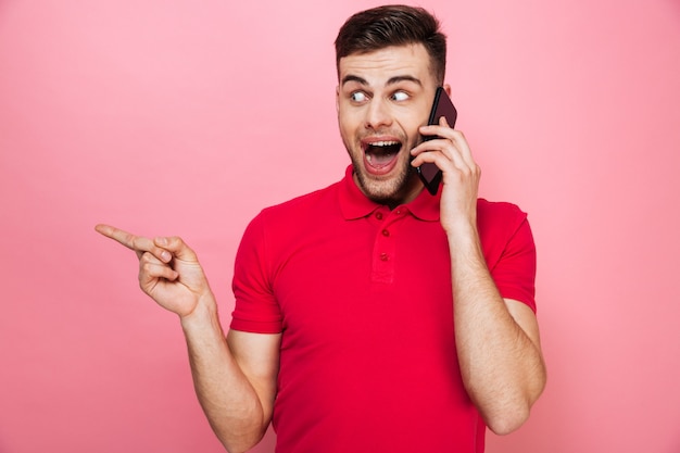 Portrait d'un jeune homme heureux parlant au téléphone mobile