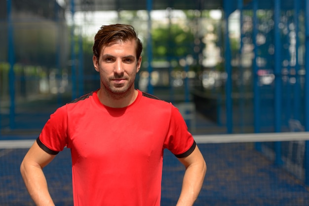 Portrait de jeune homme hispanique beau prêt à jouer à la cour de padel