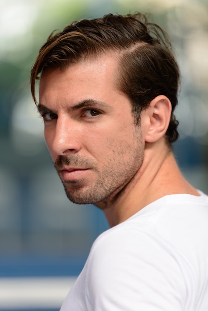 Portrait de jeune homme hispanique beau prêt à jouer à la cour de padel