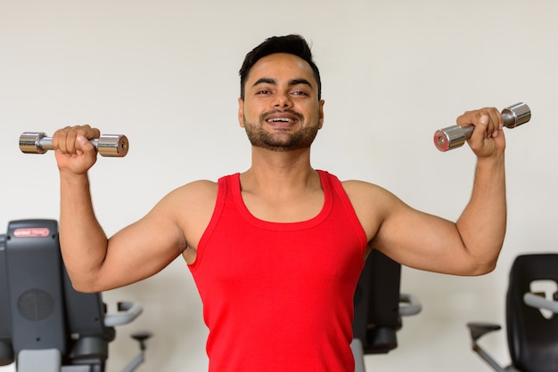 Portrait de jeune homme indien barbu beau exercice à la salle de sport