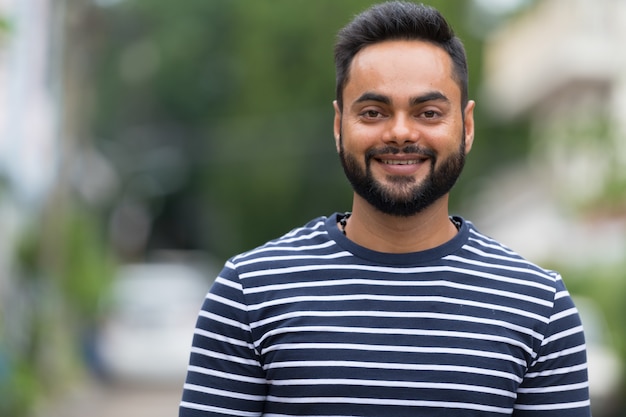 Portrait de jeune homme indien barbu dans les rues à l'extérieur