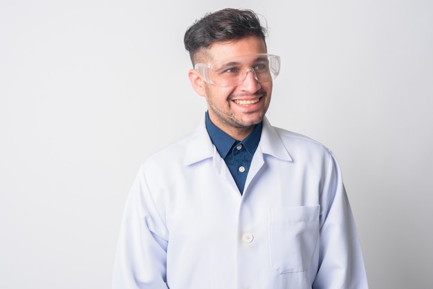 Portrait de jeune homme iranien beau médecin en tant que scientifique avec des lunettes de protection sur blanc